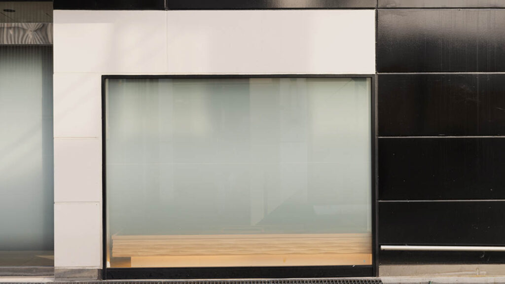 An elegant boutique storefront with a large display window, representing the in-store conversation around asking for a Birkin