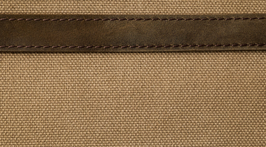 Canvas material seamed together with leather trim, representing the two versions of the Hermes Herbag compared here