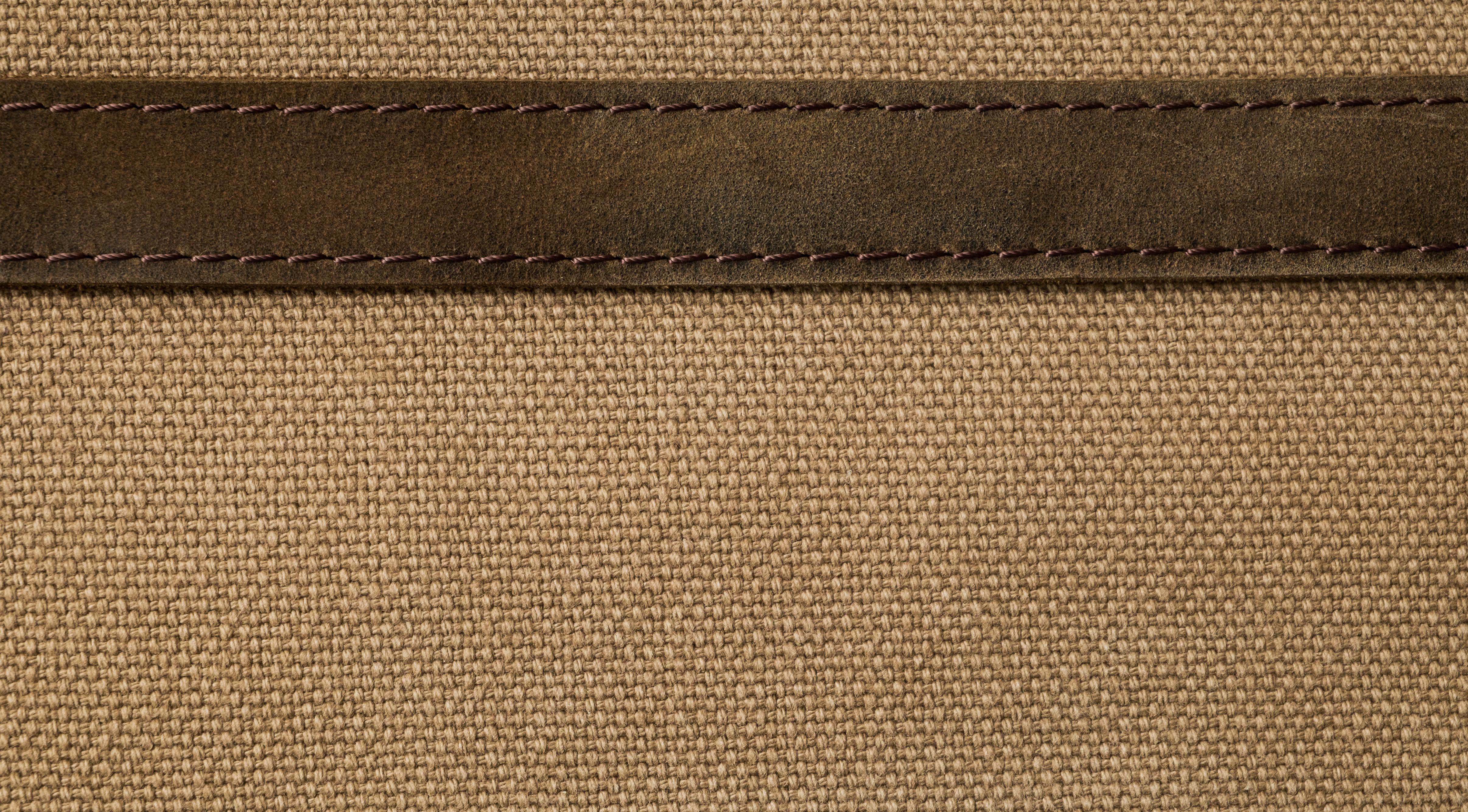 Canvas material seamed together with leather trim, representing the two versions of the Hermes Herbag compared here