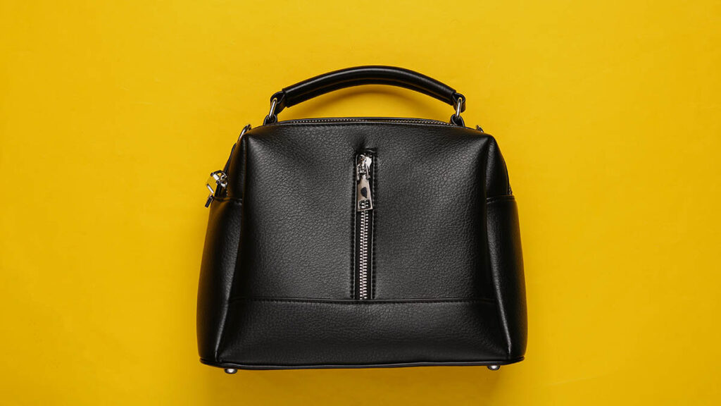 A fashionable black leather handbag with a rounded silhouette, representing the Hermes Bolide as a Birkin alternative
