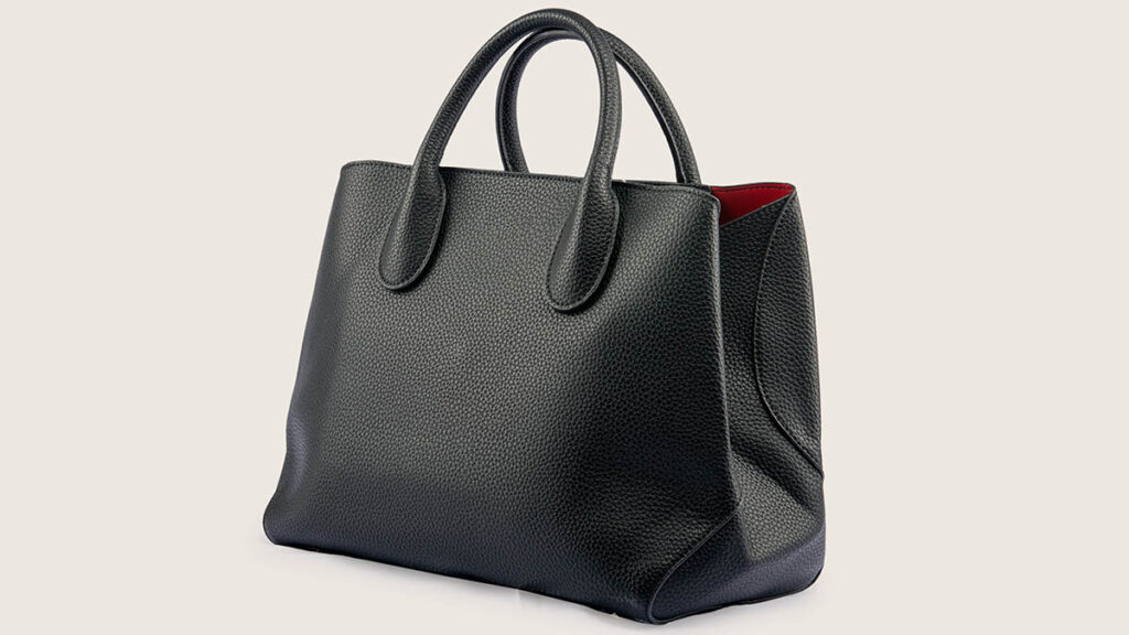 A classic structured leather handbag with a top handle, representing the range of sizes compared in the Kelly size guide