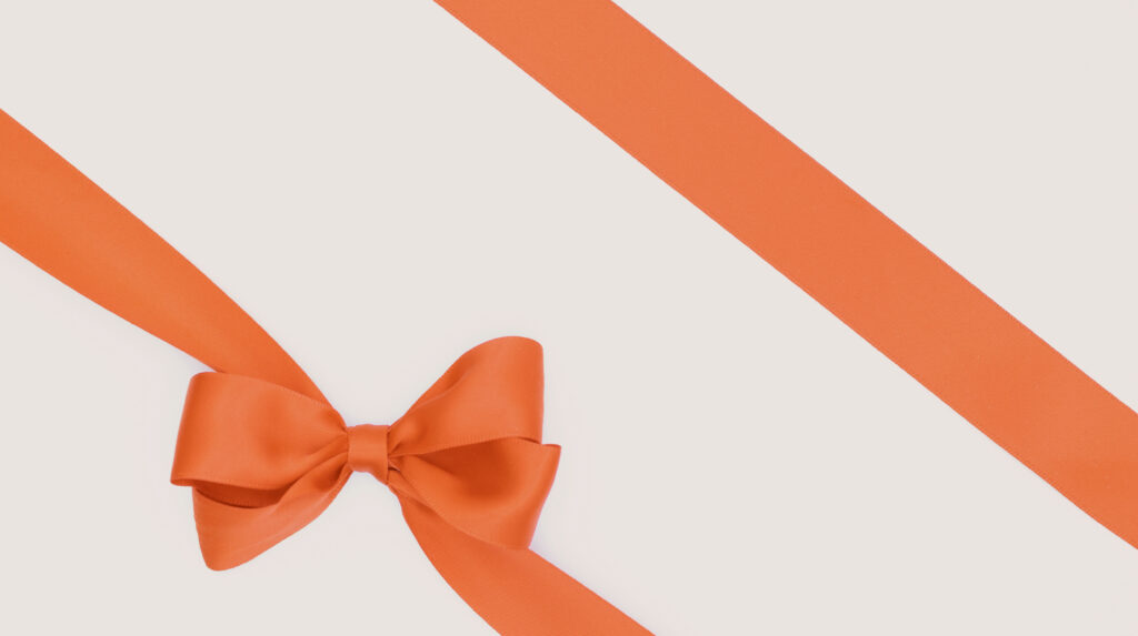 Hermès Gift Wrapping and Presentation Guide Hermxc3xa8s orange gift box with satin ribbon bow, editorial cream and gold presentation style