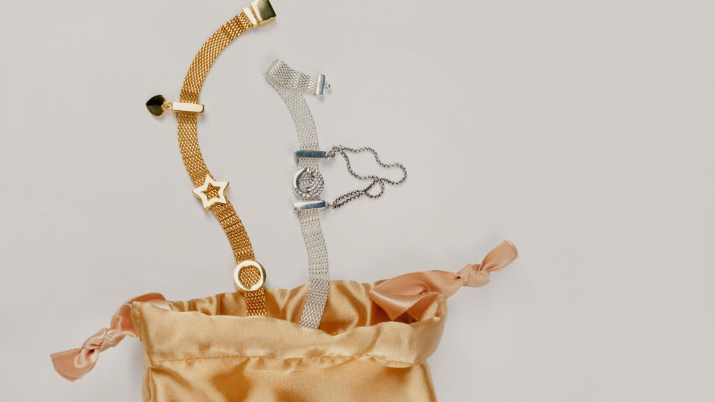 Silver and gold accessories presented in a golden silk gift pouch