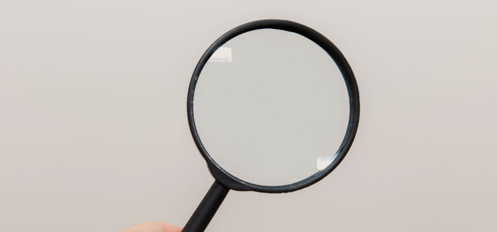 Does Leather Condition Affect Hermes Resale Price? Close inspection with a magnifying glass, representing the condition grading process that affects Hermes resale price