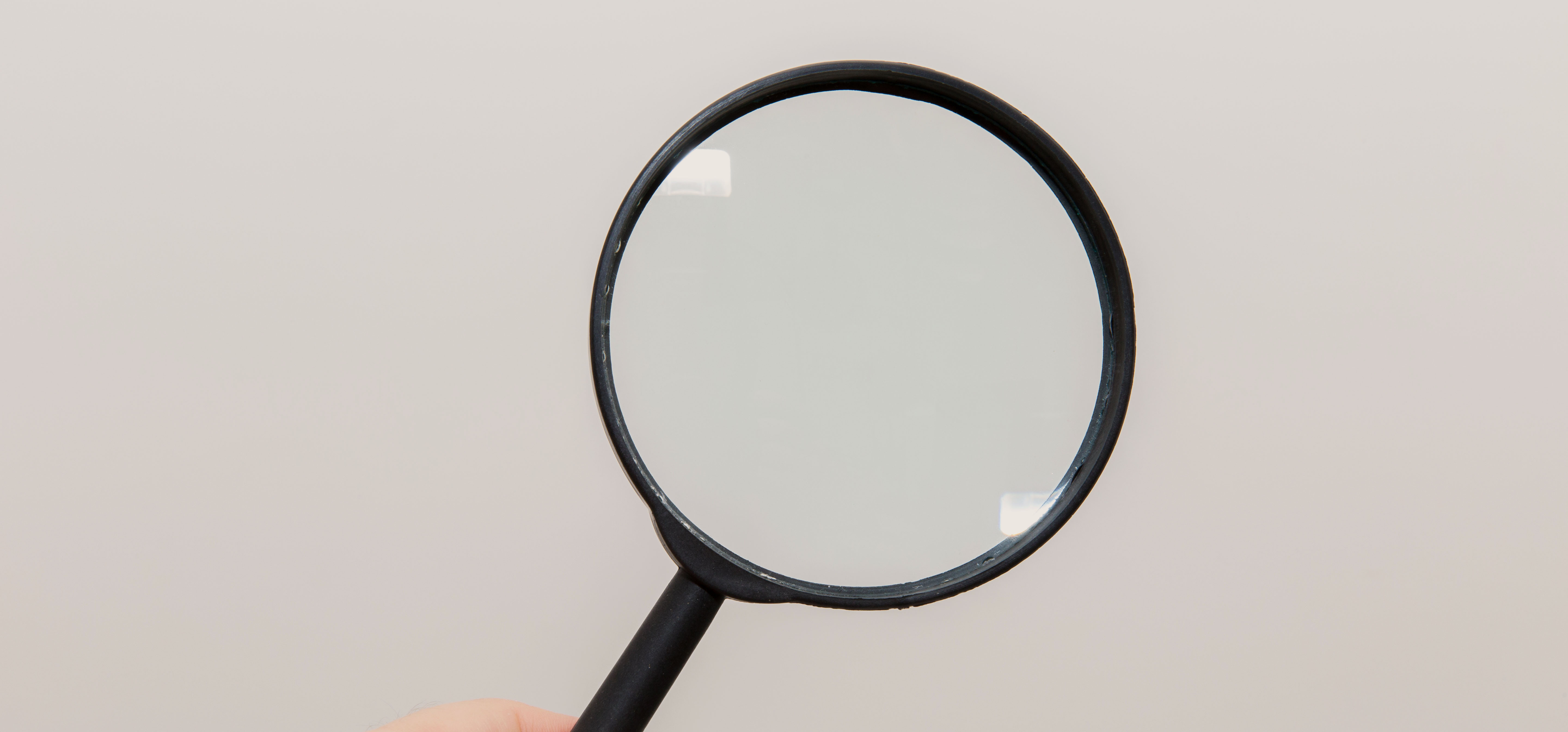 Close inspection with a magnifying glass, representing the condition grading process that affects Hermes resale price