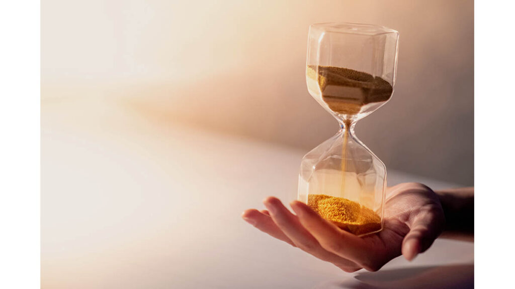 Gold sand running through an hourglass, representing common misconceptions about Hermes waitlists and timing