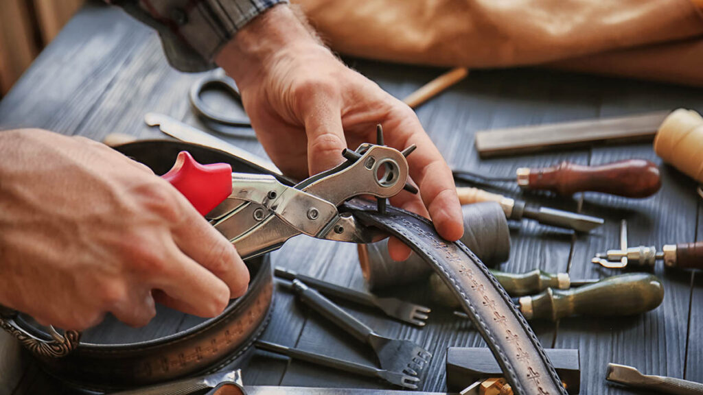 Hermes Foil Stamping Depth and Spacing: How to Read the Mark Close-up of a craftsman working leather by hand, illustrating the precision behind Hermes foil stamping