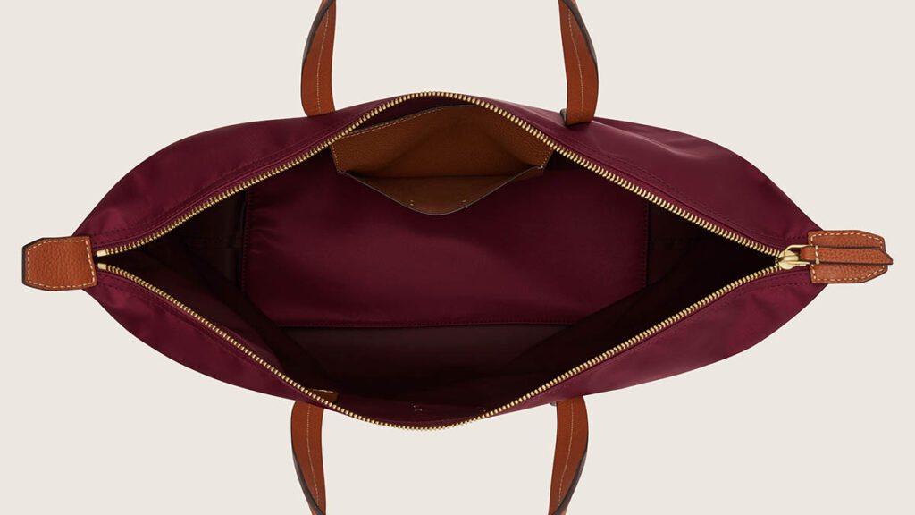 Open-top tote bag with leather handles, representing the tote styles compared between the Picotin and Garden Party