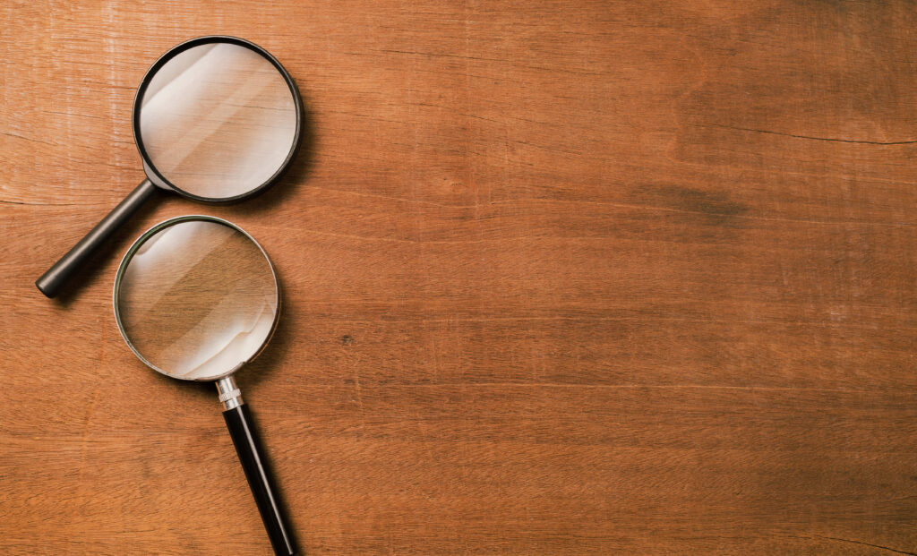 Magnifying glasses on a wooden surface, representing the careful scrutiny needed to spot an overpriced resale listing