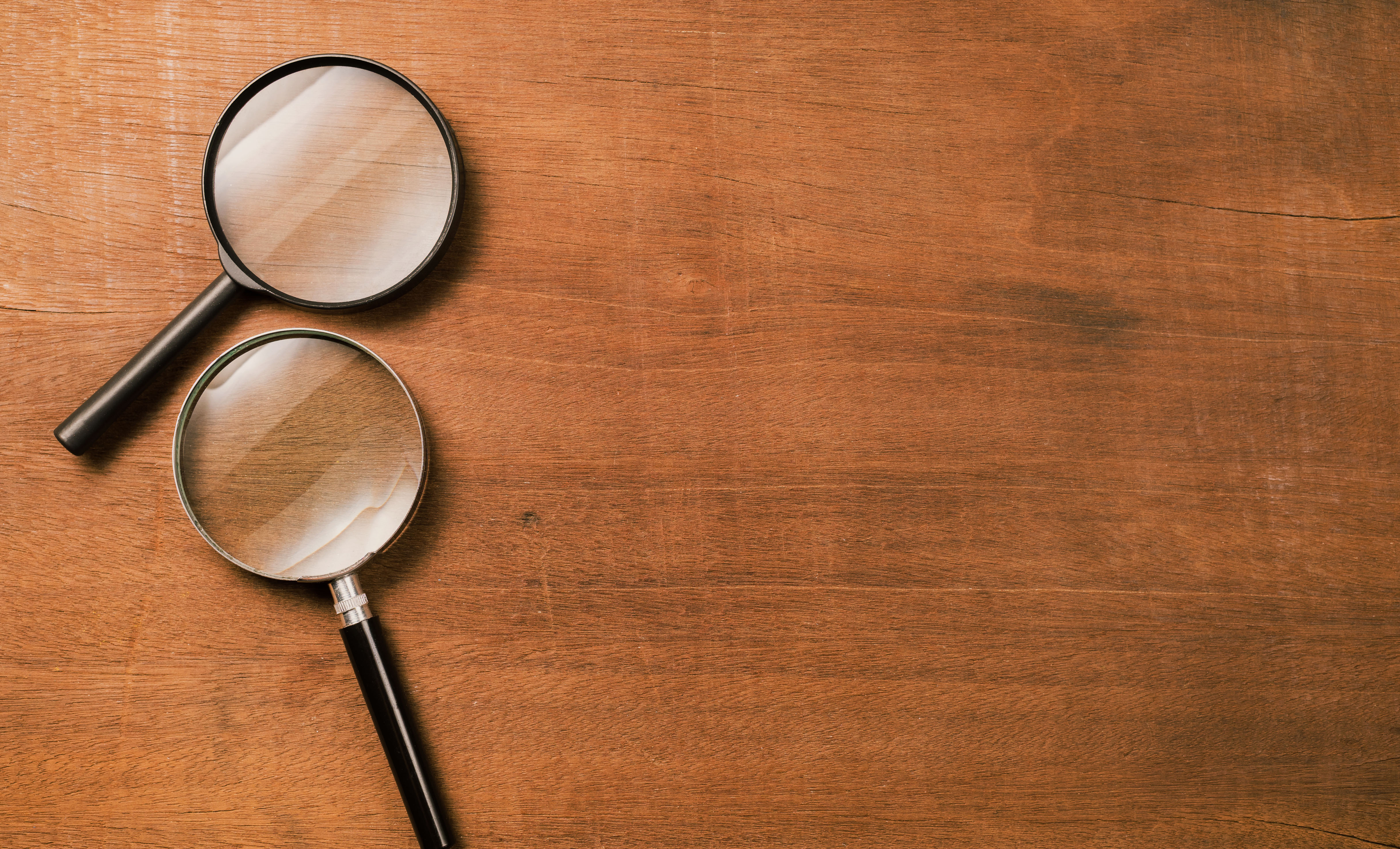 Magnifying glasses on a wooden surface, representing the careful scrutiny needed to spot an overpriced resale listing