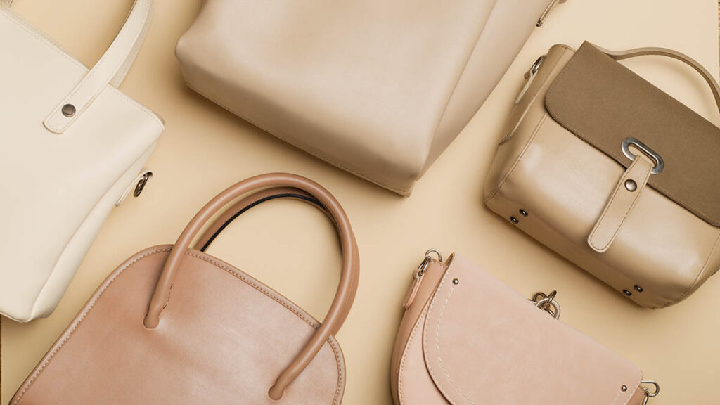 Hermès Constance vs Kelly: Which Structured Bag Fits Your Lifestyle? A structured leather bag on a wooden surface, representing the lifestyle comparison between Constance and Kelly
